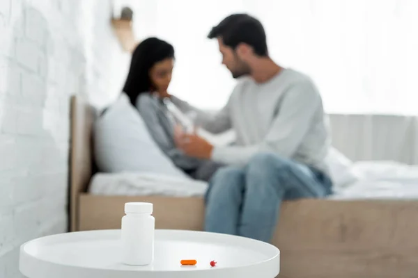 Selektiver Fokus von Pillen und Flasche auf weißem Tisch — Stockfoto