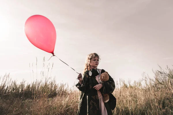 Selective focus of kid with gas mask and teddy bear holding balloon, post apocalyptic concept — Stock Photo