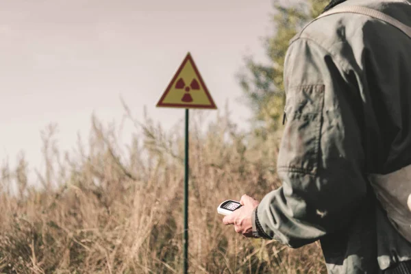 Abgeschnittene Ansicht des Menschen mit Radiometer in der Nähe toxischer Symbole, postapokalyptisches Konzept — Stockfoto