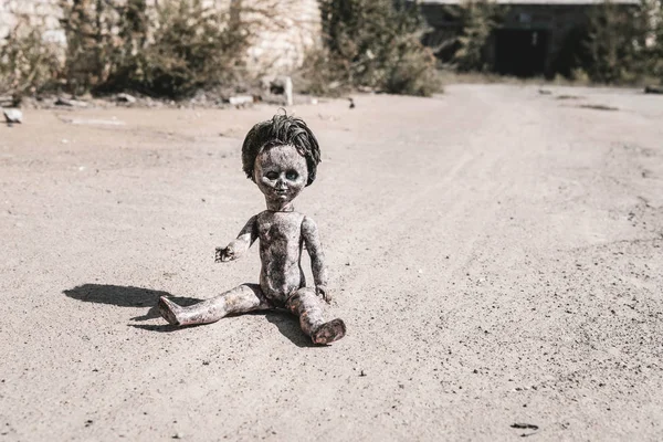 Shadow near old and scary baby doll on ground, post apocalyptic concept — Stock Photo