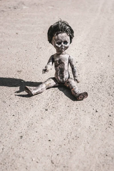 Shadow near rusty and scary baby doll on ground, post apocalyptic concept — Stock Photo