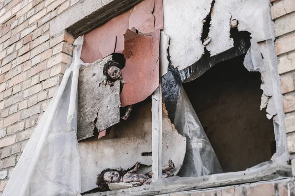 Scary and burnt baby dolls near rusty and damaged windows, post apocalyptic concept — Stock Photo