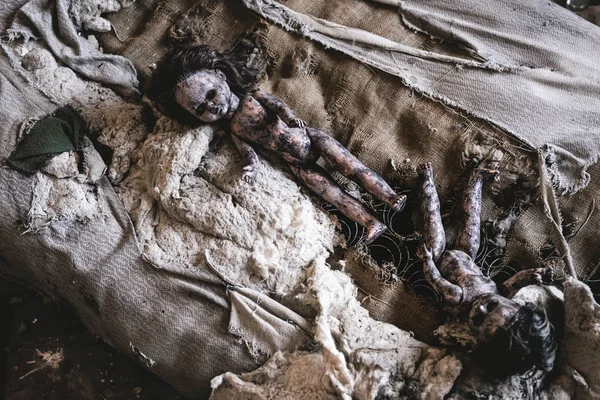 Vista superior de las muñecas de bebé asustadizas y quemadas en la cama dañada, concepto post apocalíptico - foto de stock