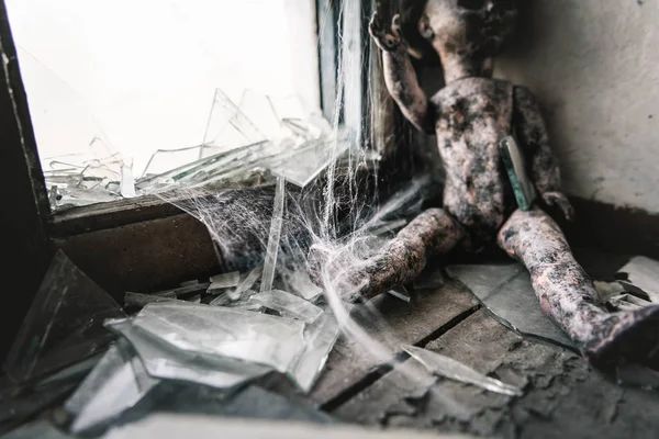 Selective focus of cobweb near scary and burnt baby doll, post apocalyptic concept — Stock Photo