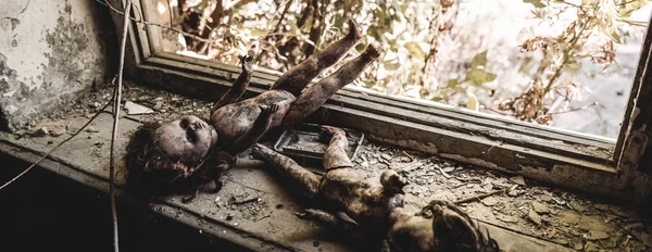 Panoramic shot of scary and burnt baby dolls near window, post apocalyptic concept — Stock Photo