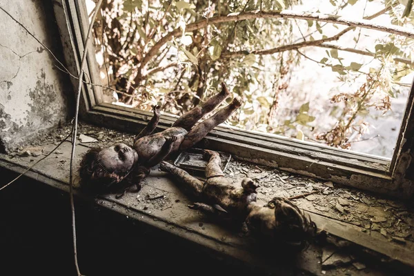 Selektiver Fokus auf beängstigende und verbrannte Babypuppen in Fensternähe, postapokalyptisches Konzept — Stockfoto