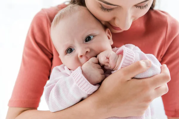 Madre che tiene in braccio adorabile figlia neonata a casa — Foto stock