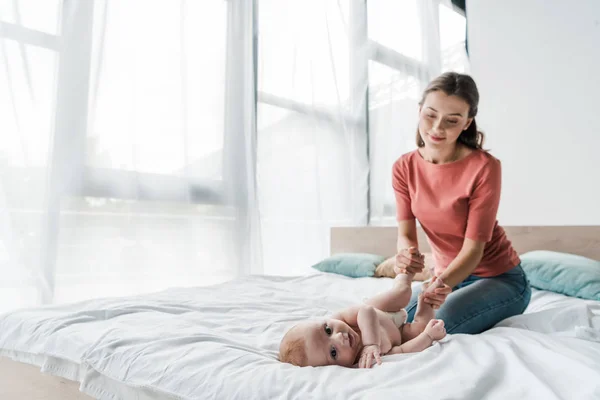 Selective focus of adorable infant looking at camera near mother — Stock Photo