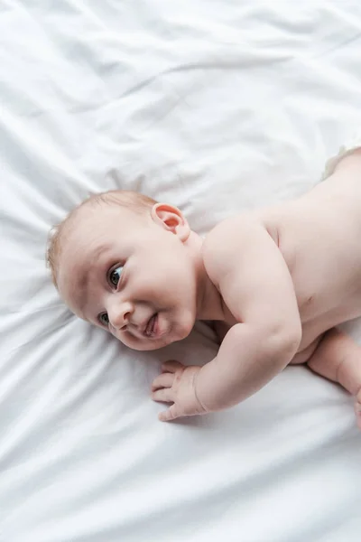 Vista superior del bebé adorable acostado en la cama en casa - foto de stock