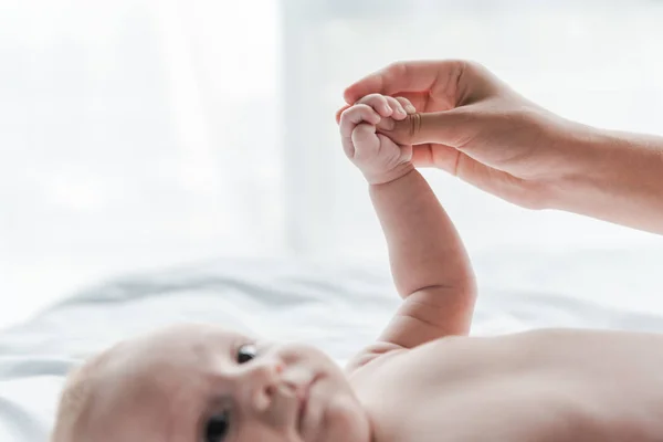 Foco seletivo da mulher tocando a mão do bebê infantil — Fotografia de Stock