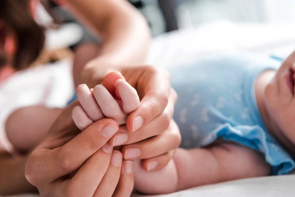 Selective focus of mother doing massage of infant daughter — Stock Photo