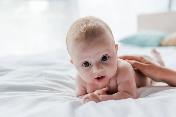 Ausgeschnittene Ansicht einer Frau, die Baby-Tochter auf Bett liegend berührt — Stockfoto