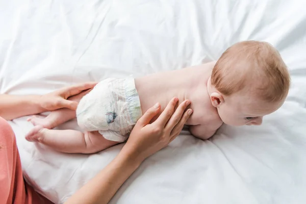 Vue de dessus de la mère touchant bébé fille en couche — Photo de stock