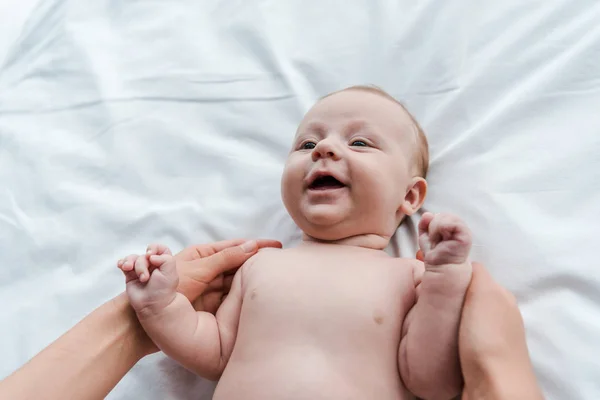 Blick von oben: Mutter berührt glückliche Säuglingstochter im Bett — Stockfoto