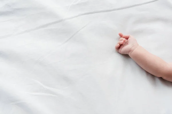 Обрезанный вид младенца, лежащего на кровати — стоковое фото