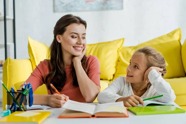 Selektiver Fokus glücklicher Kinder auf Babysitter mit Stift im Wohnzimmer — Stockfoto