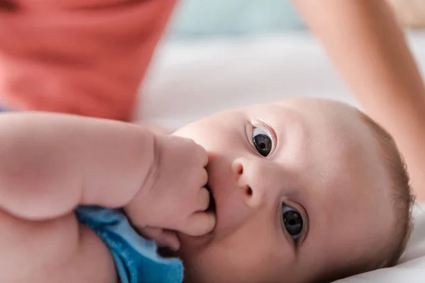 Foco seletivo de bonito bebê filha chupando dedos no quarto — Fotografia de Stock