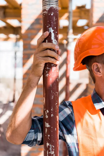 Vista recortada de constructor maduro en casco naranja - foto de stock