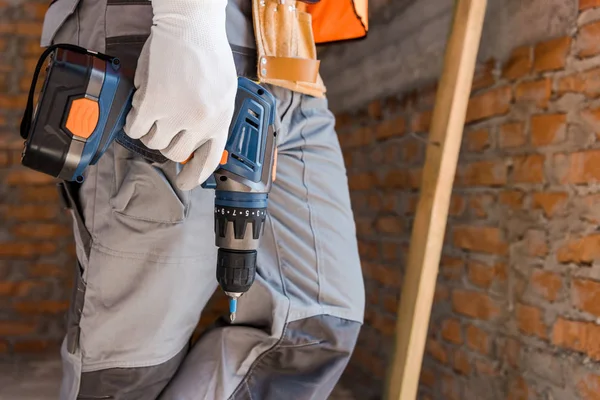 Cropped view of constructor holding hammer drill — Stock Photo