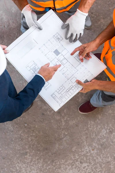 Vista cortada de construtores e empresário de pé e segurando o projeto — Fotografia de Stock