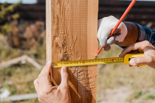 Vista ritagliata del costruttore che tiene il nastro di misurazione — Foto stock