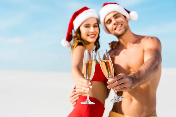 Selektiver Fokus von sexy Freundin und Freund, die mit Champagnergläsern klirren und sich am Strand der Malediven umarmen — Stockfoto