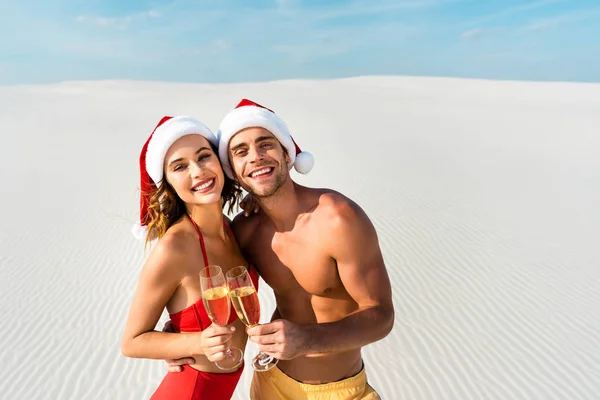 Sexy girlfriend and boyfriend clinking with champagne glasses and hugging on beach in Maldives — Stock Photo