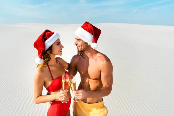 Sexy girlfriend and boyfriend clinking with champagne glasses and hugging on beach in Maldives — Stock Photo