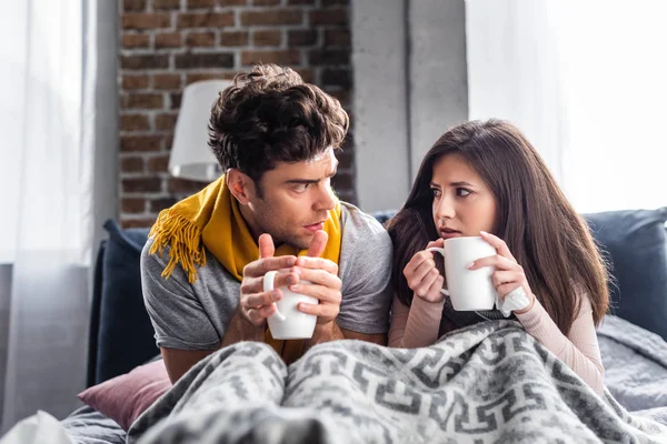 Namorada doente e namorado segurando copos com chá — Fotografia de Stock