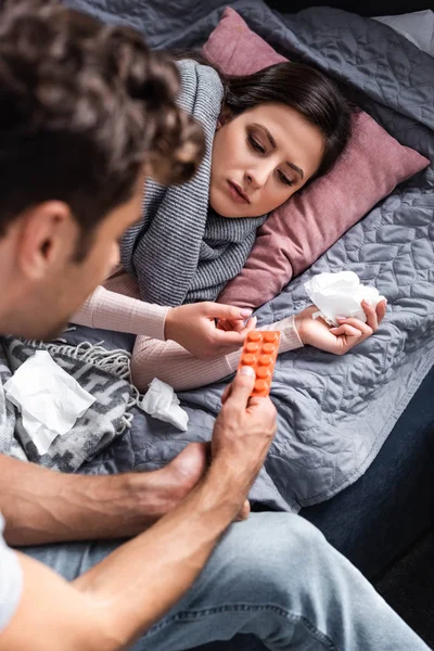 Recortado vista de novio dando pastillas a la novia enferma - foto de stock