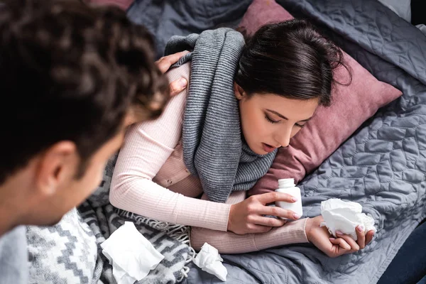 Foyer sélectif de petite amie malade tenant serviette et bouteille avec pilule — Photo de stock