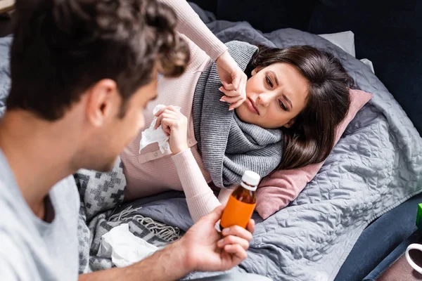 Cropped view of boyfriend giving cough syrup to sick girlfriend — Stock Photo