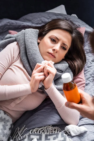 Cropped view of boyfriend giving cough syrup to sick girlfriend — Stock Photo