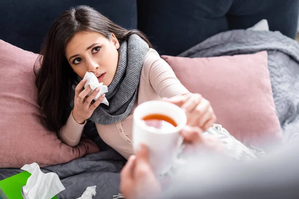 Recortado vista de novio dando taza de té a la novia enferma - foto de stock