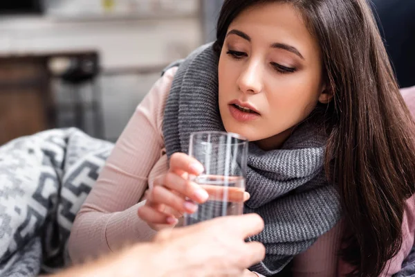 Vista ritagliata del fidanzato che dà un bicchiere d'acqua alla ragazza malata — Foto stock