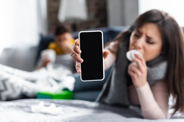 Selective focus of sick girlfriend holding smartphone with copy space — Stock Photo
