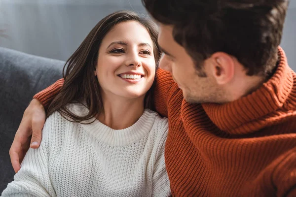 Namorada atraente e namorado em suéteres sorrindo e abraçando no apartamento — Fotografia de Stock