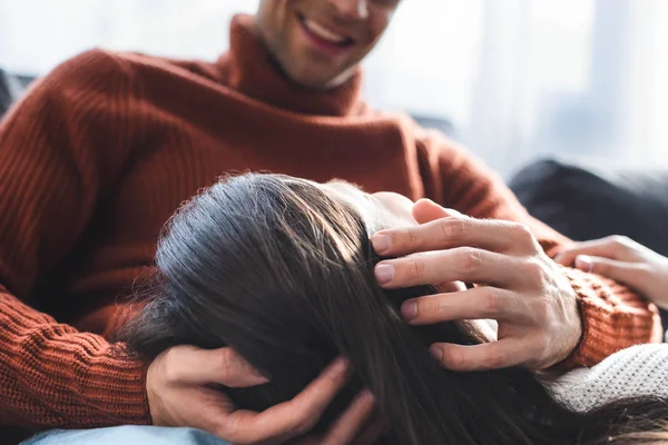 Vue recadrée de petite amie en pull couché sur les genoux de petit ami — Photo de stock