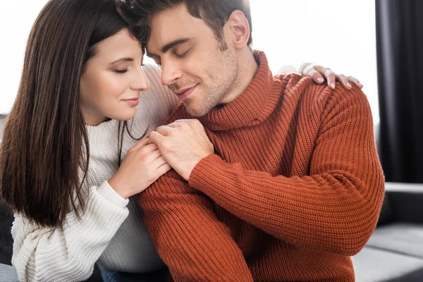 Attractive girlfriend and handsome boyfriend in sweaters holding hands — Stock Photo