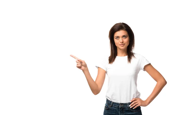 Bela mulher em t-shirt branca apontando para algo, isolado em branco — Fotografia de Stock
