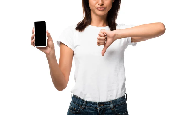 Vista recortada de la mujer que muestra el pulgar hacia abajo y el teléfono inteligente con pantalla en blanco, aislado en blanco - foto de stock