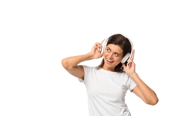 Fröhliche junge Frau, die mit Kopfhörern Musik hört, isoliert auf weiß — Stockfoto