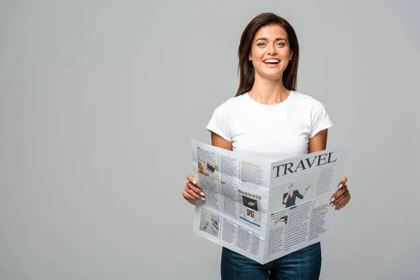 Beautiful excited woman holding travel newspaper, isolated on grey — Stock Photo