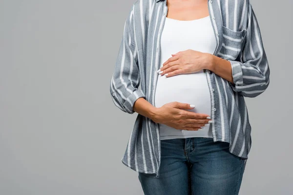 Cropped view of pregnant girl touching tummy isolated on grey — Stock Photo