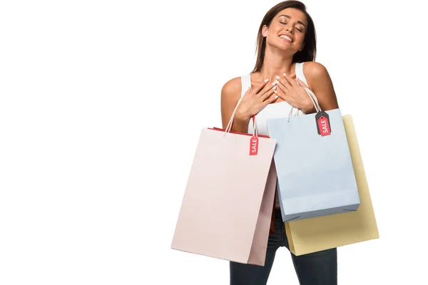 Mulher feliz segurando sacos de compras com sinais de venda, isolado em branco — Fotografia de Stock