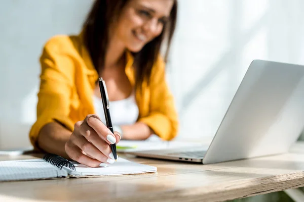 Foco seletivo da escrita freelancer e trabalhar com laptop em home office — Fotografia de Stock