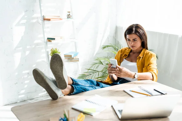 Femme indépendante confiante travaillant avec smartphone au bureau à domicile — Photo de stock