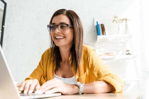 Belo freelancer sorrindo trabalhando com laptop em home office — Fotografia de Stock