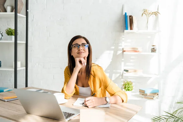 Bella freelance sognante che lavora con il computer portatile in home office — Foto stock