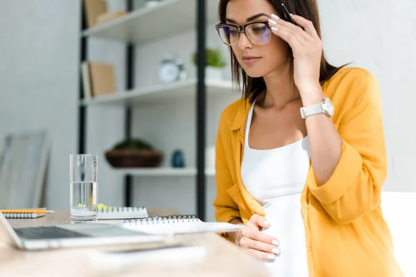Pregnant freelancer working with laptop in home office — Stock Photo